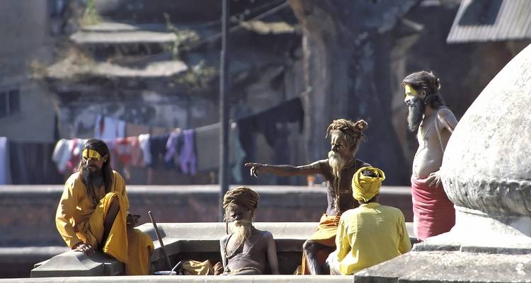 Elderly sadhus sitting in conversation.