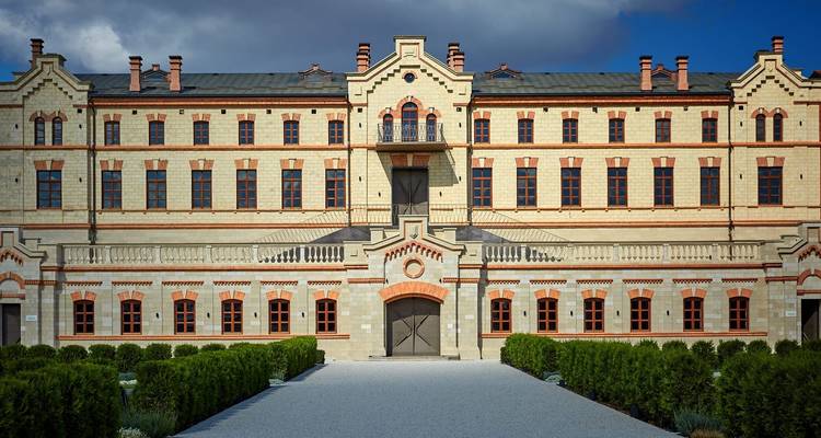 Bâtiment en pierre avec un jardin entretenu.