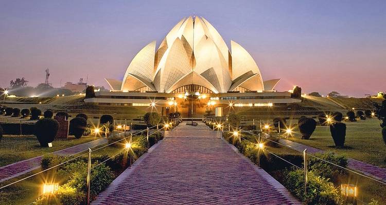 Lotus Tempel verlicht in de schemering met een goed verlicht pad dat ernaar toe leidt.