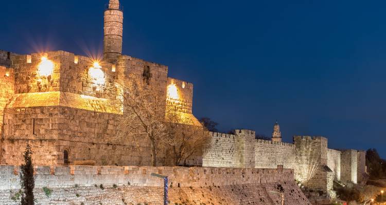 Un fuerte histórico de noche con murallas iluminadas.