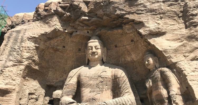 Des statues en pierre sculptée dans un cadre rocheux.