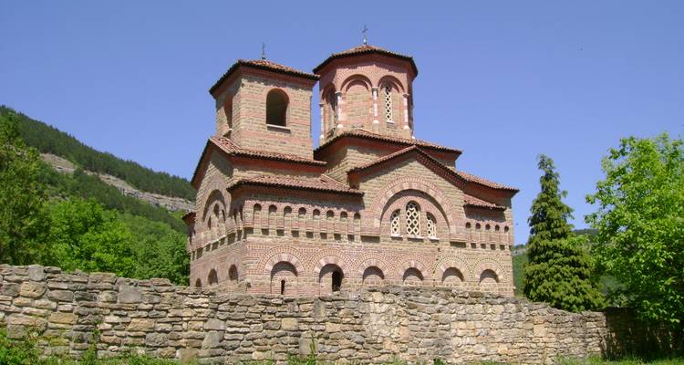 Vieille église en brique avec des arbres en arrière-plan.