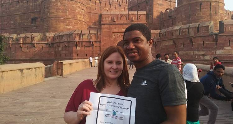 Toeristen die een bord vasthouden voor een rood fort