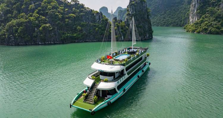 Luchtfoto van een cruiseschip dat door het prachtige landschap van Halong Bay vaart.