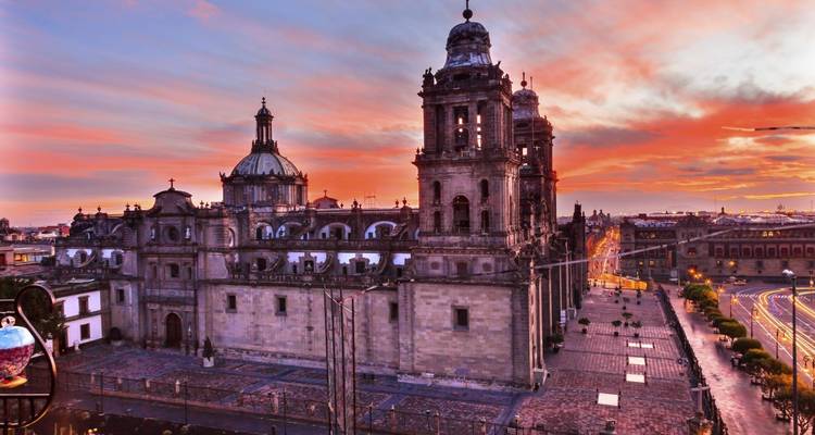 Sunset over Mexico City’s Metropolitan Cathedral and Zócalo with vivid pink and orange skies.