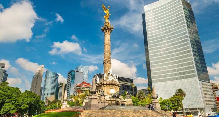 Iconic Angel of Independence column gleaming against Mexico City's skyline under a vivid blue sky.