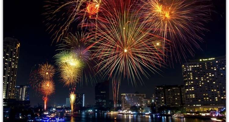 Fireworks display over a city river at night.