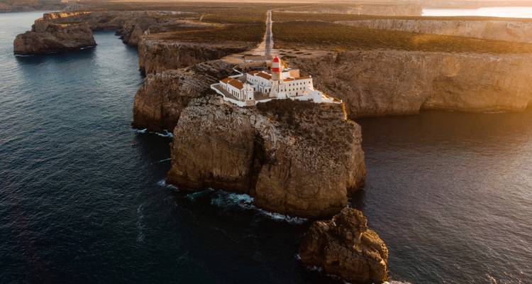 Vista aérea del atardecer del faro de Cabo de São Vicente encaramado en acantilados del mar espectaculares.