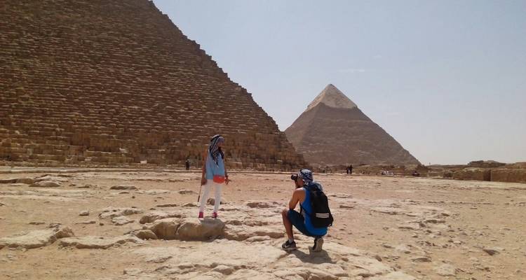 Two people posing in front of pyramids.