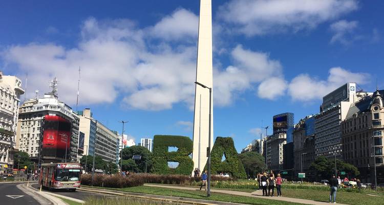 Buenos Aires Obelisk rises above landscaped BA topiary letters in a bustling city avenue.