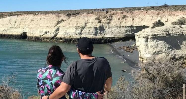 Couple overlooking a bay with white cliffs and sandy beach.