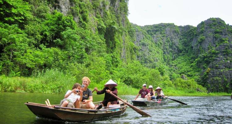 Touristen genießen eine Bootsfahrt durch malerische Flussklippen.