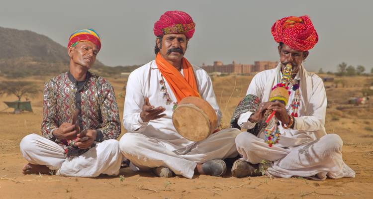 Drei traditionelle Musiker sitzen in der Wüste