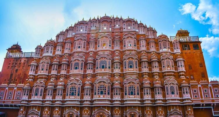 Verzierte rosa Fassade des Hawa Mahal, die sich gegen einen strahlend blauen Himmel erhebt.