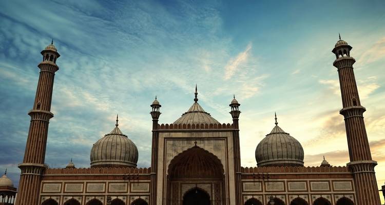 Silhouette der Jama Masjid mit dramatischem Abendhimmel und sanften Sonnenuntergangsfarben.