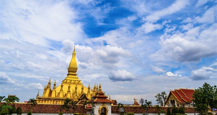 Gouden stoepa en tempelbouwen onder een blauwe hemel.