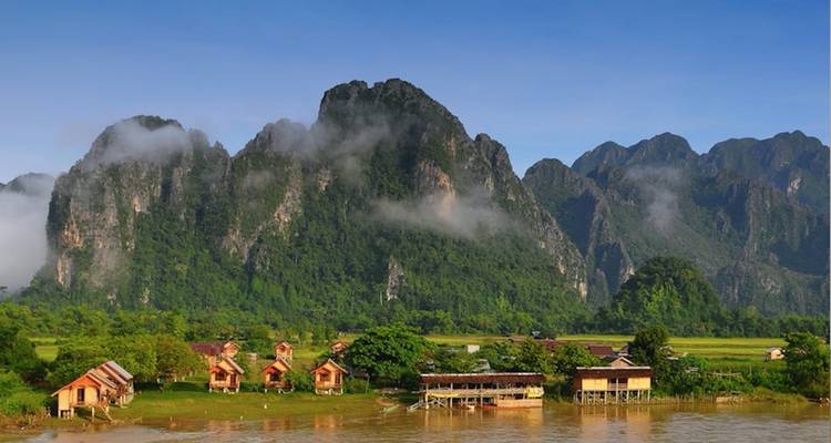 Rivierdorp met opvallende kalkstenen bergen.