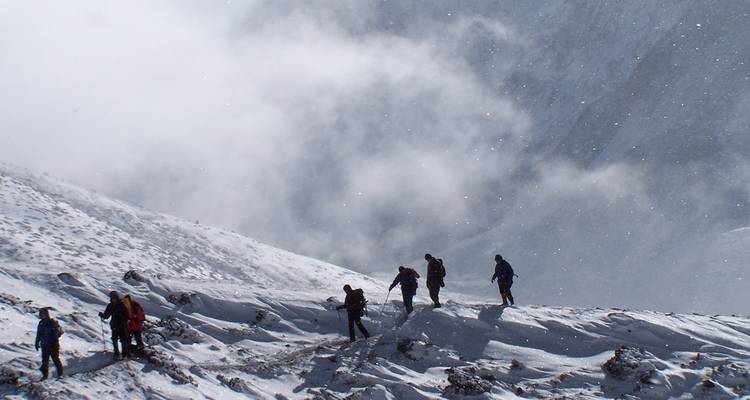 Hikers in snowy mountainous terrain.
