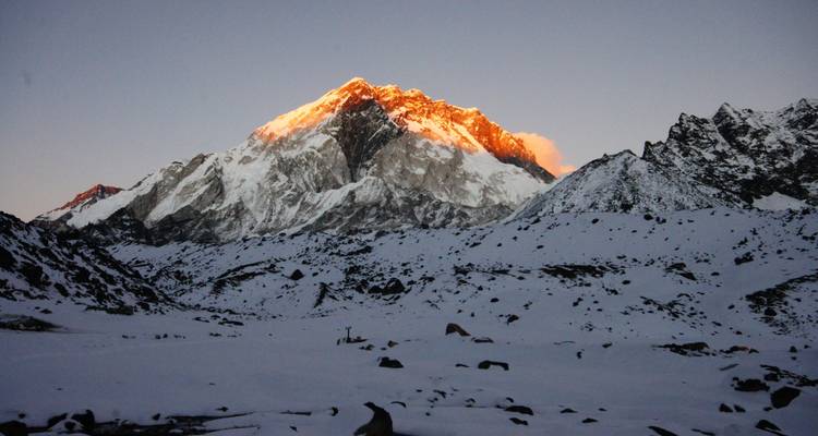 Snow-covered mountains with a sunlit peak.