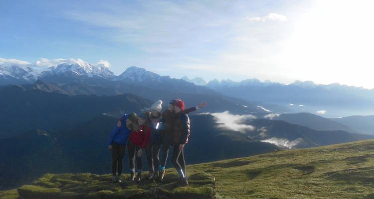 Groep vrienden die poseren op een bergkam met verre bergtoppen.