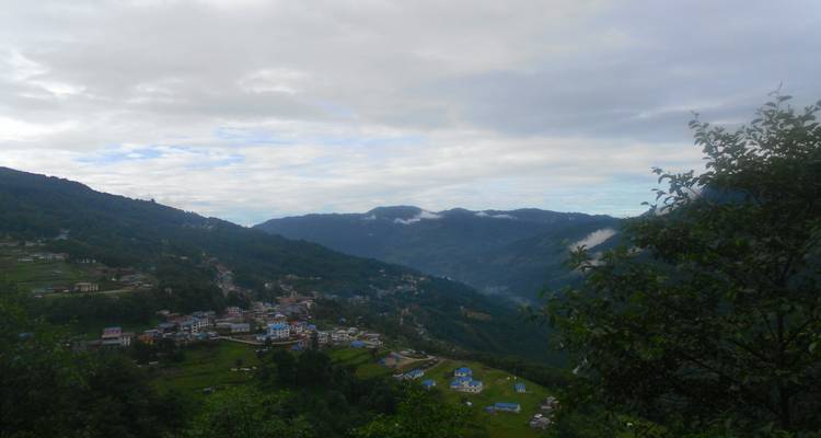 Klein dorp op een heuvelflank met omringende bergen.