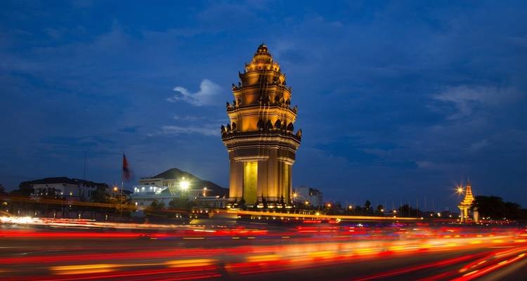 A tall, illuminated tower with traffic light trails, possibly in Phnom Penh, Cambodia.