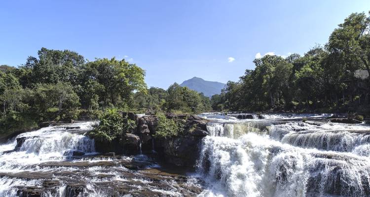Rushing waterfall with a mountain in the backdrop