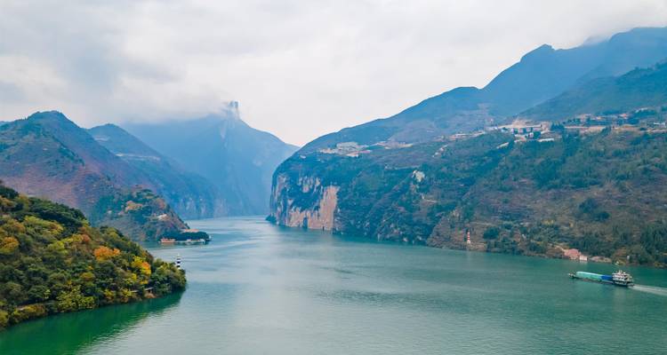 Garganta del río Verde con pico brumoso distante y asentamientos en las laderas bajo nubes dispersas