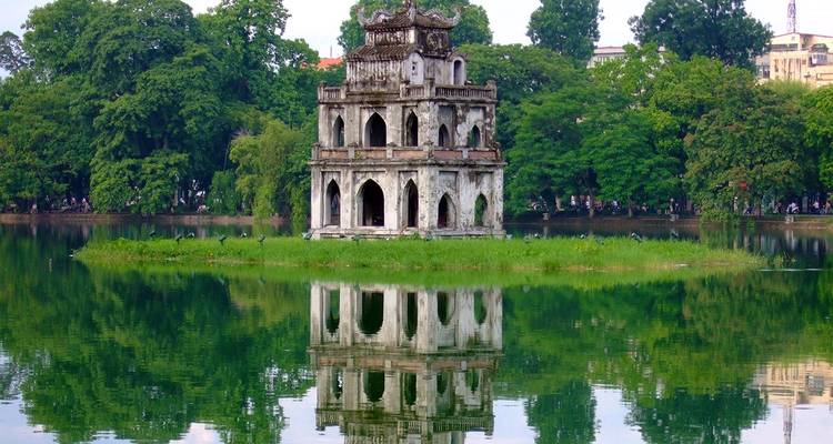 Oude tempel weerspiegeld in een serene meer omgeven door weelderige groen.