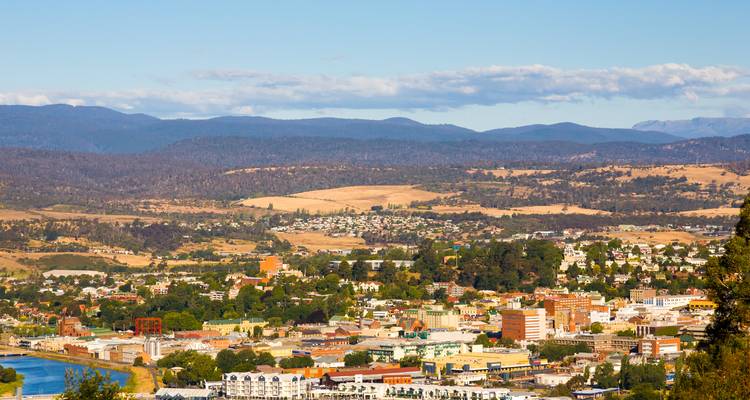 Expansive view across Launceston’s suburbs to distant forested hills under a bright blue Tasmanian sky.