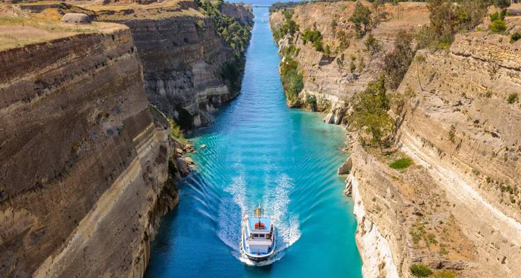 Barco de tour navegando por las sorprendentes aguas color turquesa del Canal de Corinto de paredes escarpadas.