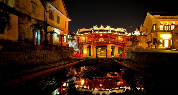 Colorful lights reflecting off the canal water at night.