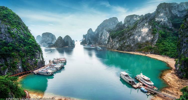 Scenic bay with docks and boats surrounded by limestone karsts.