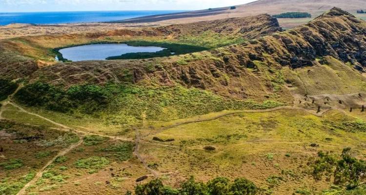 Luftaufnahme des vulkanischen Rano-Kau-Kraters mit einem Süßwassersee inmitten von hügeliger grüner Landschaft.