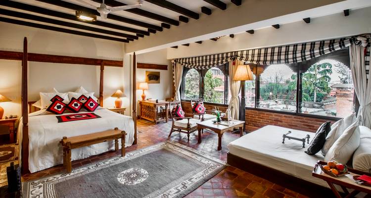 Luxueuze kamer met traditionele inrichting en grote ramen.