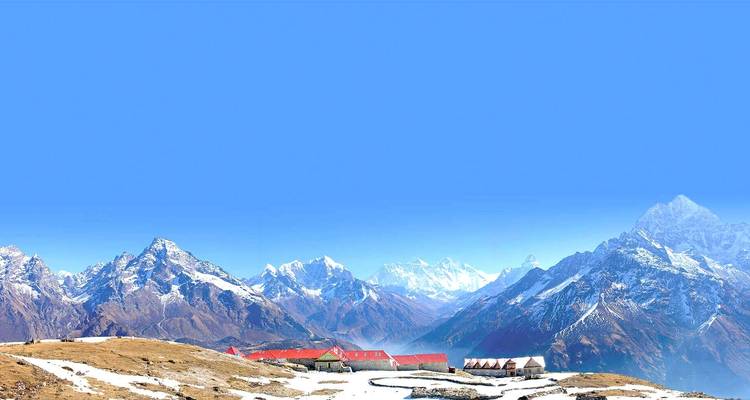 Snowy mountain range with a small settlement at the foothills.
