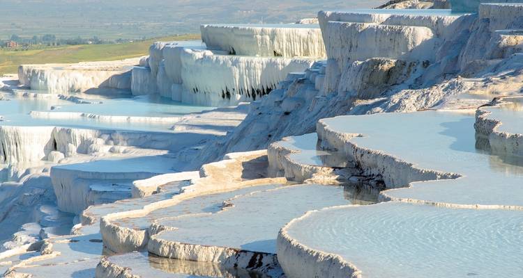 Terraced natural pools with white mineral deposits.