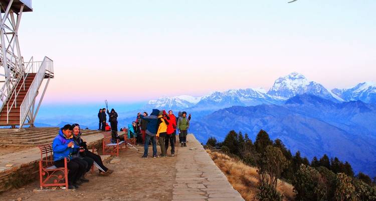 Turistas en Poon Hill con un paisaje montañoso de fondo.