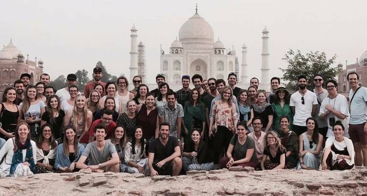 Große Gruppe von Touristen, die vor dem Taj Mahal posiert.