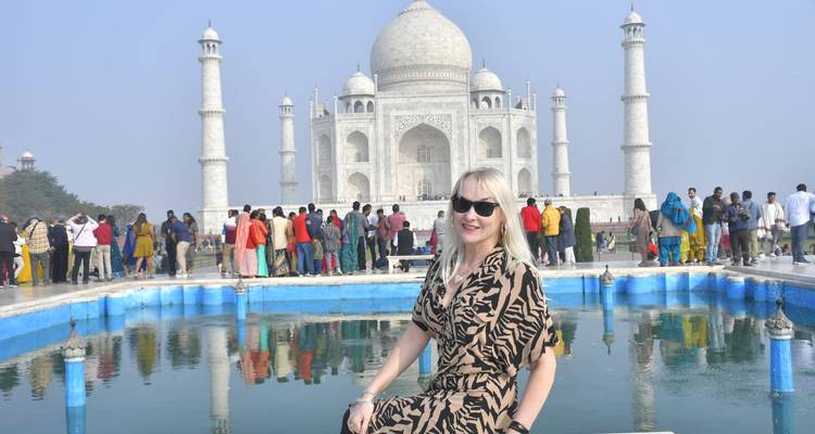 Femme posant près du bassin de réflexion du Taj Mahal avec une image miroir nette.