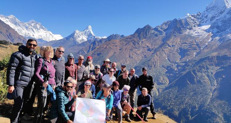 Große Trekkinggruppe mit einer Bergkette im Hintergrund.