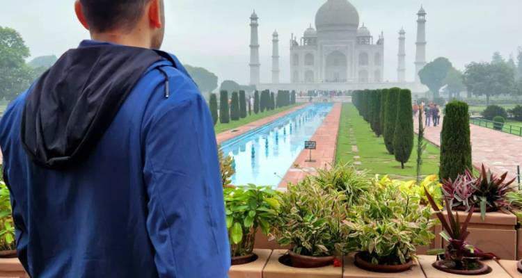 Un homme regardant le Taj Mahal à distance.