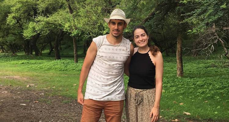 Deux personnes en tenue décontractée se tenant debout dans une clairière forestière.