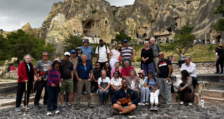 Large group photo at a famous outdoor site with rocky terrains.