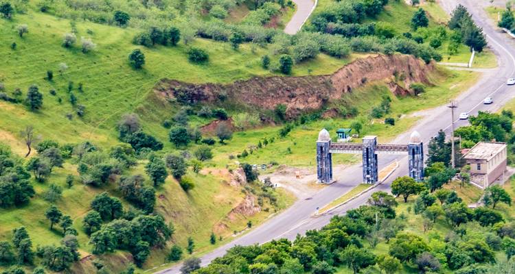 Vue aérienne d'un portail d'autoroute pittoresque au milieu des arbres et des collines.