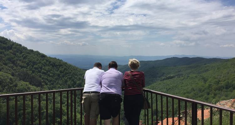 Des gens profitant d'une vue panoramique sur les collines depuis une rambarde.