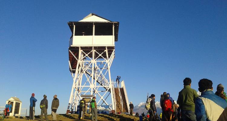 Group of people at a watchtower in a mountainous area.