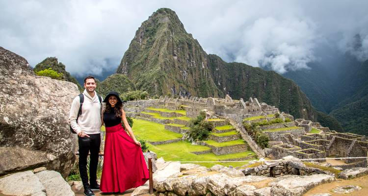 Pareja posando en Machu Picchu con fondo paisajístico.
