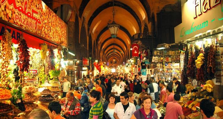 Escena animada de mercado con gente y puestos coloridos.