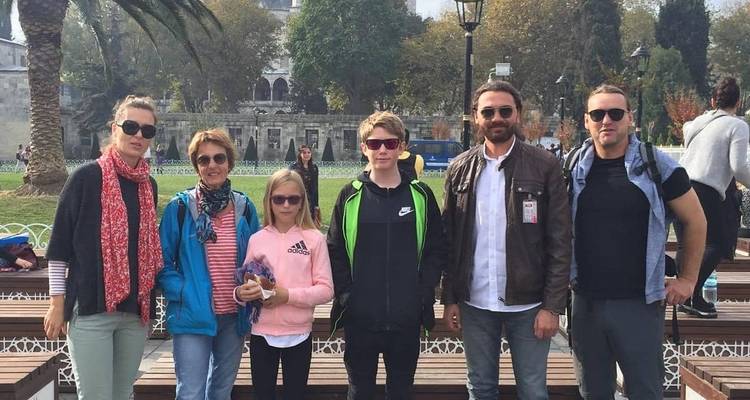 Un grupo de seis personas posando juntas al aire libre con ropa informal.